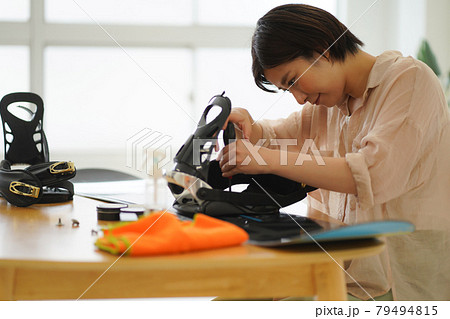 スノーボード板の手入れをする女性 79494815