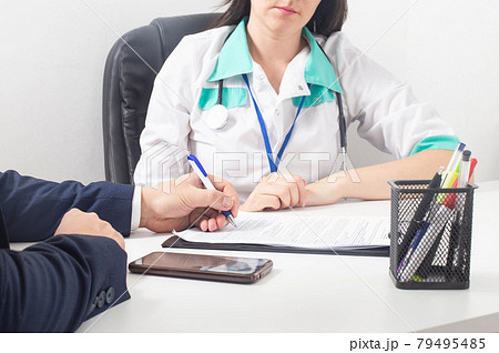 The patient signs a document for consent to anesthesia and surgery 79495485