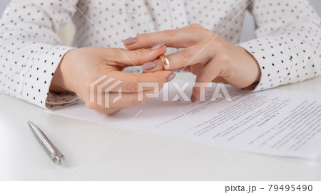 Close-up woman signed divorce papers and took off her wedding ring 79495490