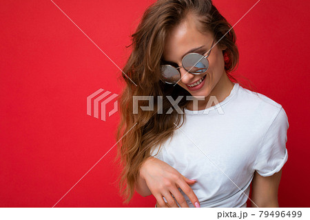 Attractive happy smiling young blonde woman wearing everyday stylish clothes and modern sunglasses 79496499