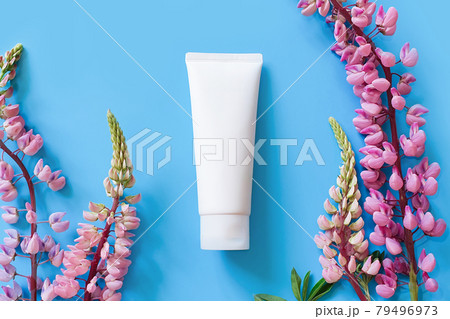 Unbranded white cosmetic squeeze tube and bright lupine flowers on blue background. Mockup, template. Container for body lotion, moisturizer cream, shower gel, shaving cream. Unbranded white cosmetic squeeze tube and bright lupine flowers on blue background. Mockup, template. Container for body lotion, moisturizer cream, shower gel, shaving cream. 79496973
