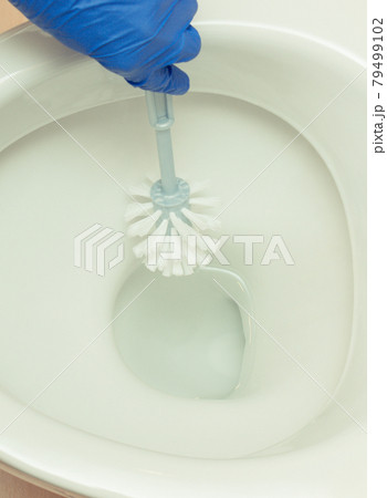 Hand of cleaner using brush for cleaning toilet. Household duties concept Hand of cleaner using brush for cleaning toilet. Household duties concept 79499102
