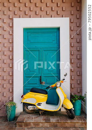 yellow motorcycle at the turquoise wooden door yellow motorcycle at the turquoise wooden door 79502552
