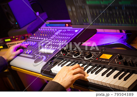 music producer, arranger, DJ hands remixing music on synthesizer keyboard, control surface and computer in home recording studio 79504389