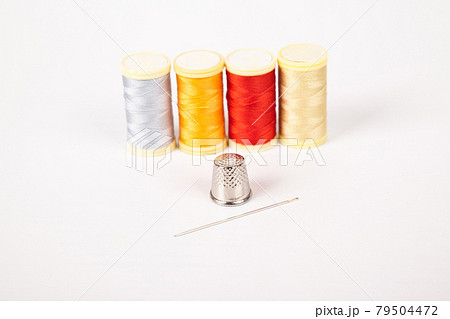 Sewing supplies, colorful threads needle and thimble, isolated on white background 79504472