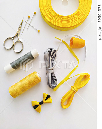 Flat lay with sewing kit and sewing accessories in trend Illuminating yellow and ultimate gray ribbon colours 79504578