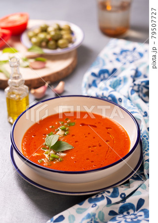 Plate of traditional spanish gazpacho in the background ingredients with white-blue patterned napkin 79507727