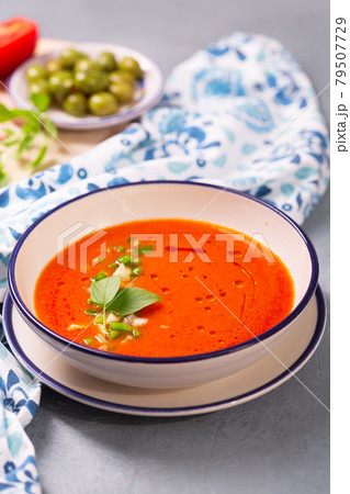 Plate of traditional spanish gazpacho in the background ingredients with white-blue patterned napkin 79507729
