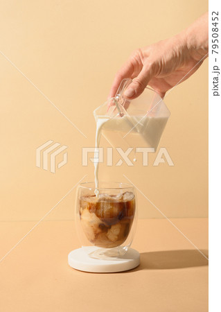 Iced latte coffee in cup glass with pouring milk Iced latte coffee in cup glass with pouring milk 79508452