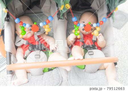 ベビーカーに乗っている双子の赤ちゃん ベビーカーに乗っている双子の赤ちゃん 79512663