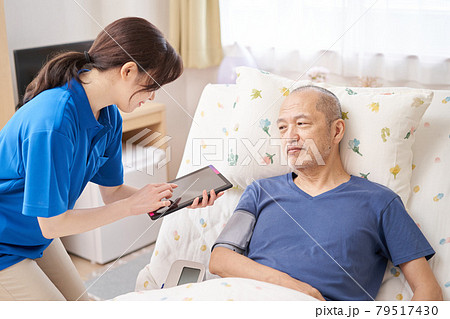 タブレットで血圧を測る介護士 タブレットで血圧を測る介護士 79517430