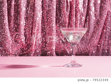 Martini cocktail background pink shiny curtain. Alcoholic classic drink with ice in elegant glass for the celebration Martini cocktail background pink shiny curtain. Alcoholic classic drink with ice in elegant glass for the celebration 79522349