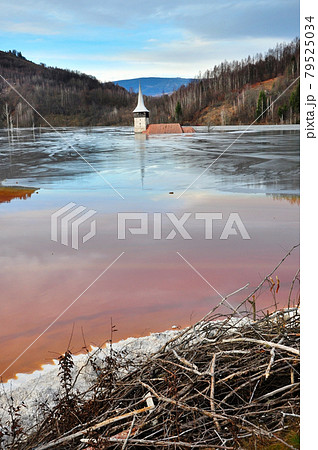A flooded church in a toxic red lake. Water polluting by a copper mine A flooded church in a toxic red lake. Water polluting by a copper mine 79525034