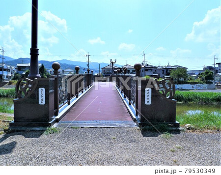 奈良県桜井市金屋、仏教伝来の地の立て札と石碑がある大和川沿いの河川敷の風景、うまいでばし 79530349