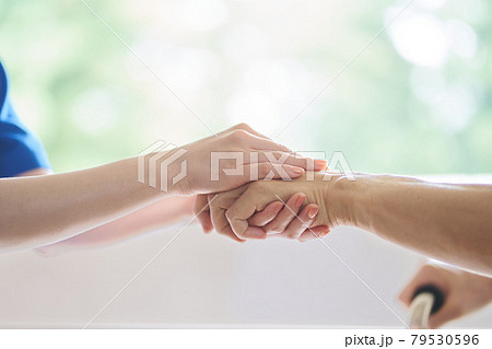 介護士と高齢者の手元 79530596