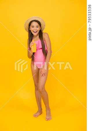 Small girl in swimsuit hold sunscreen cosmetics cream, pool beach or seaside rest concept Small girl in swimsuit hold sunscreen cosmetics cream, pool beach or seaside rest concept 79533536
