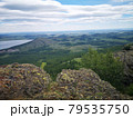 A large stone on the background of mountains with trees 79535750