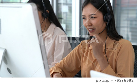 Businesswoman wearing headset working actively in office 79536995