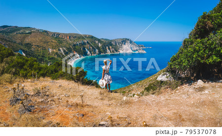 Panoramic aerial photo of a tourist woman enjoying beautiful Petani beach on Kefalonia Ionian island, Greece, during her summer vacation holiday Panoramic aerial photo of a tourist woman enjoying beautiful Petani beach on Kefalonia Ionian island, Greece, during her summer vacation holiday 79537078