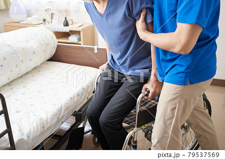 高齢者の介助をする介護士 79537569