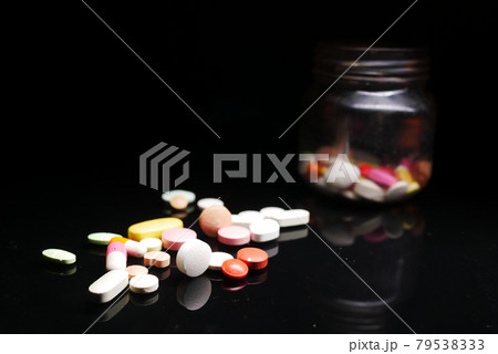 Close up of many colorful pills and capsules on black background Close up of many colorful pills and capsules on black background 79538333