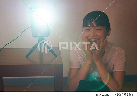 家庭用プロジェクターで動画を観る女性 79540165