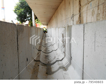 SELANGOR, MALAYSIA -DECEMBER 02, 2016: Construction workers laying precast concrete drain at the construction site.  79540603