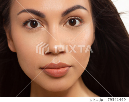 Closeup of beauty women with clean skin, full lips and long dark hair. Looks at the camera and shows skin care. Increased skin texture around the eyes and lips. Smile on face 79541449