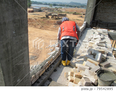 JOHOR, MALAYSIA -DECEMBER 05, 2016: Bricklayer lay bricks to form building walls at the construction site. JOHOR, MALAYSIA -DECEMBER 05, 2016: Bricklayer lay bricks to form building walls at the construction site. 79542895