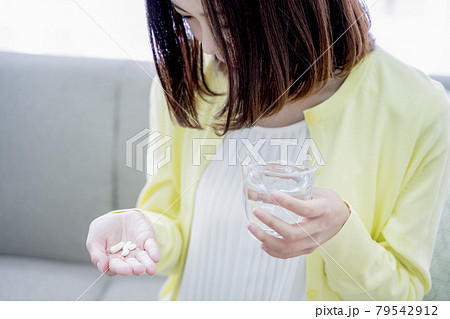 サプリを飲む女性 79542912
