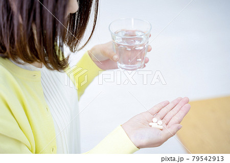 サプリを飲む女性 79542913