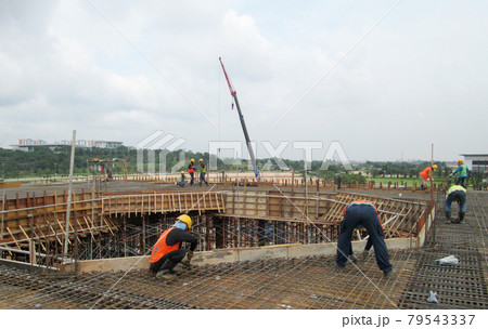 MALACCA, MALAYSIA -SEPTEMBER 24, 2016: Construction workers fabricating floor slab reinforcement bar at the construction site in Malacca, Malaysia. MALACCA, MALAYSIA -SEPTEMBER 24, 2016: Construction workers fabricating floor slab reinforcement bar at the construction site in Malacca, Malaysia. 79543337