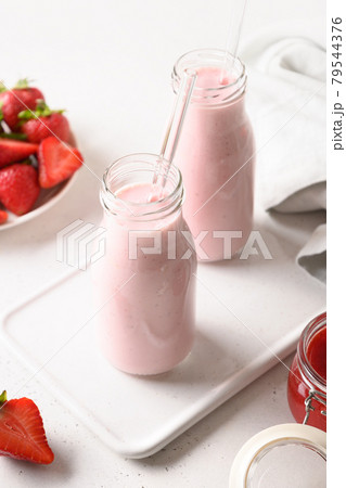 Indian strawberry lassi or milkshake in bottle on gray. Indian strawberry lassi or milkshake in bottle on gray. 79544376