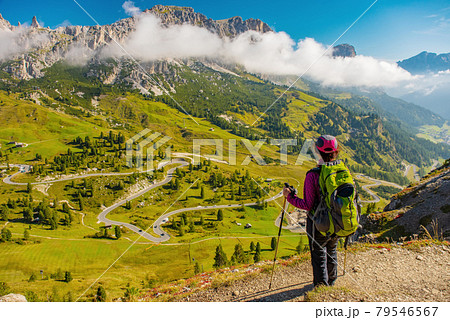 Active hiker hiking, enjoying the view, looking at Dolomites mountains landscape 79546567