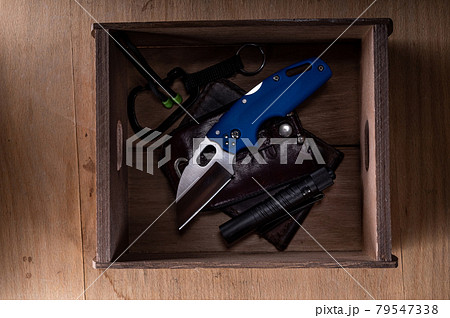 Pocket knife and other everyday items. Wallet and knife in a box. Carabiner and knife. Flat lay. Top view. 79547338