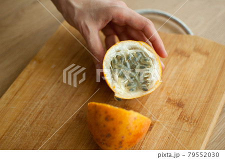 Fresh organic ripe granadilla or yellow passion fruit cut in half on a wooden board. Exotic fruits, healthy eating concept Fresh organic ripe granadilla or yellow passion fruit cut in half on a wooden board. Exotic fruits, healthy eating concept 79552030