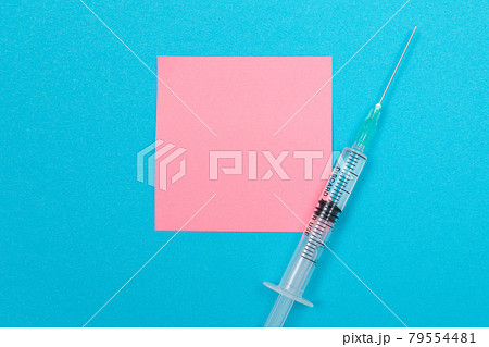Vaccination or Revaccination Concept - A Medical Syringe on Blue Table Vaccination or Revaccination Concept - A Medical Syringe on Blue Table 79554481