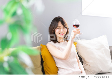 家でワインを楽しむ若い女性 79554841