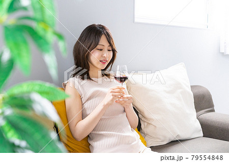 家でワインを楽しむ若い女性 79554848