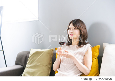 家でワインを楽しむ若い女性 79554850