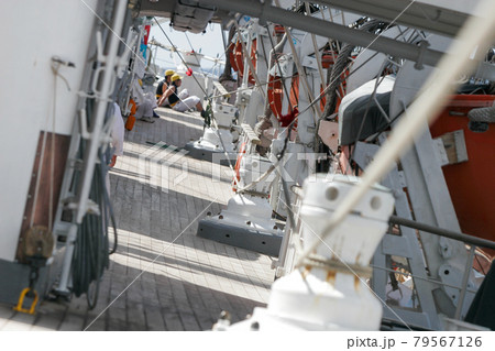 大きく傾斜して帆走する帆船、甲板上に張られた安全索 79567126