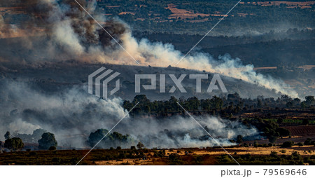 Devastated field with smoke trails during the fire Devastated field with smoke trails during the fire 79569646