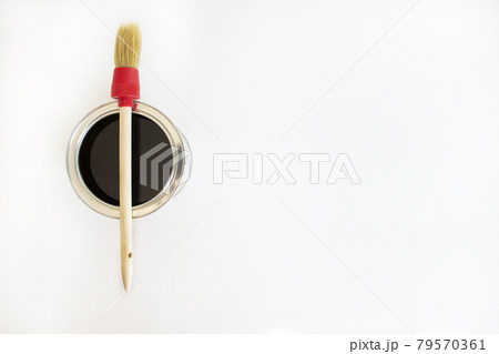 Paint symbol. A round paint brush lies on a can of paint on a white background. Copy space. Business and paint concept. Paint symbol. A round paint brush lies on a can of paint on a white background. Copy space. Business and paint concept. 79570361