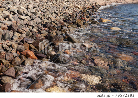 the waves rolled on shore with pebbles 79572393