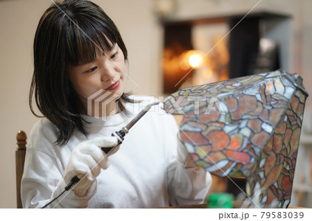ステンドグラスのランプを作る女性 79583039