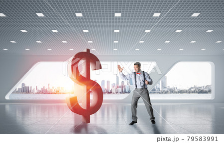 Determined banker man in modern office interior breaking dollar figure Determined banker man in modern office interior breaking dollar figure 79583991