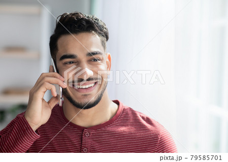 Happy middle-eastern guy talking on mobile phone 79585701