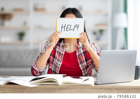 Female Student Holding Leaflet With Drawn Help Word In Front Of Face Female Student Holding Leaflet With Drawn Help Word In Front Of Face 79586132