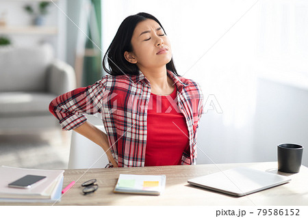 Beautiful Young Asian Woman Suffering From Backache While Working In Home Office 79586152