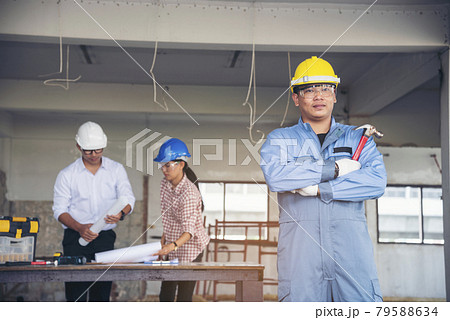 Construction engineer teamwork Safety Suit Trust Team Holding White Yellow Safety hard hat Security Equipment on Construction Site. Hardhat Protect Head for Civil Construction Engineer Concept 79588634